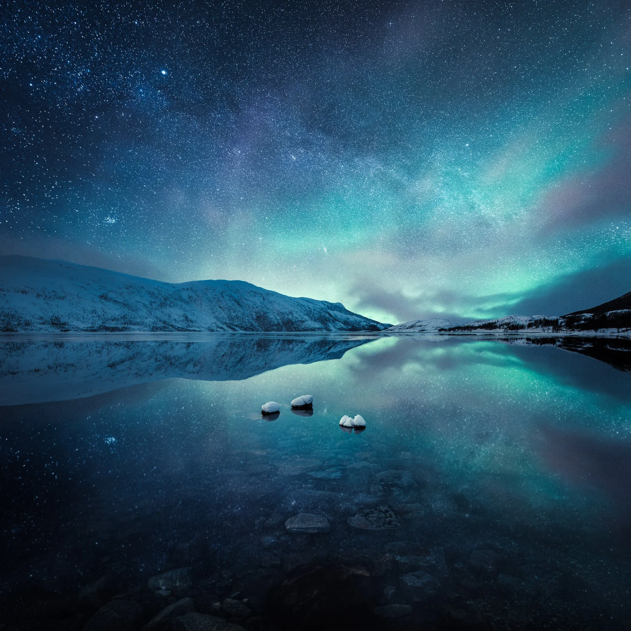 Small boat on still water beneath a star-filled night sky in an atmospheric coastal landscape by Mikko Lagerstedt