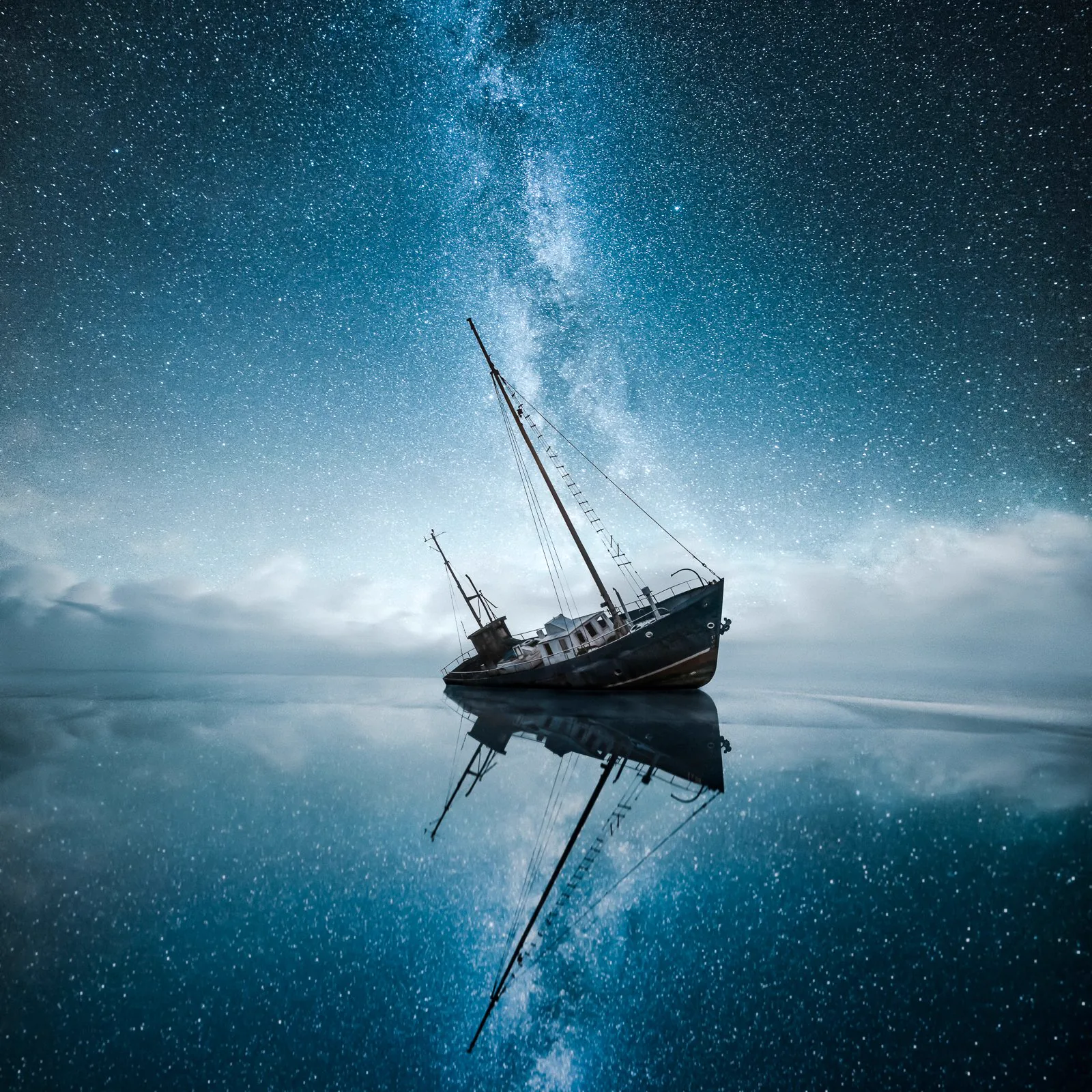 Night sky over a stranded boat reflected in calm water from the Edge collection by Mikko Lagerstedt