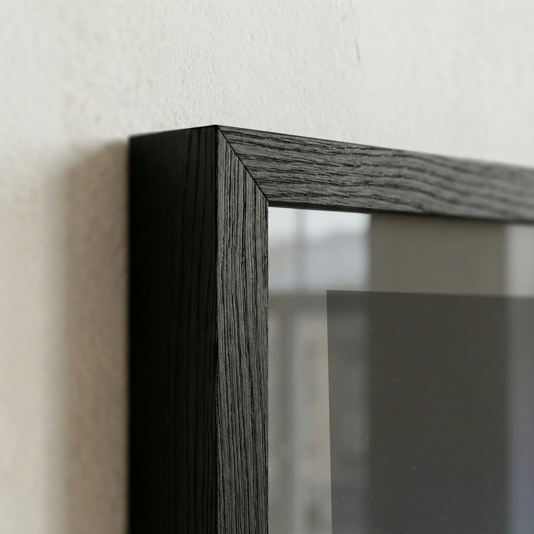 Close detail of a black frame profile and glazing on a fine art print