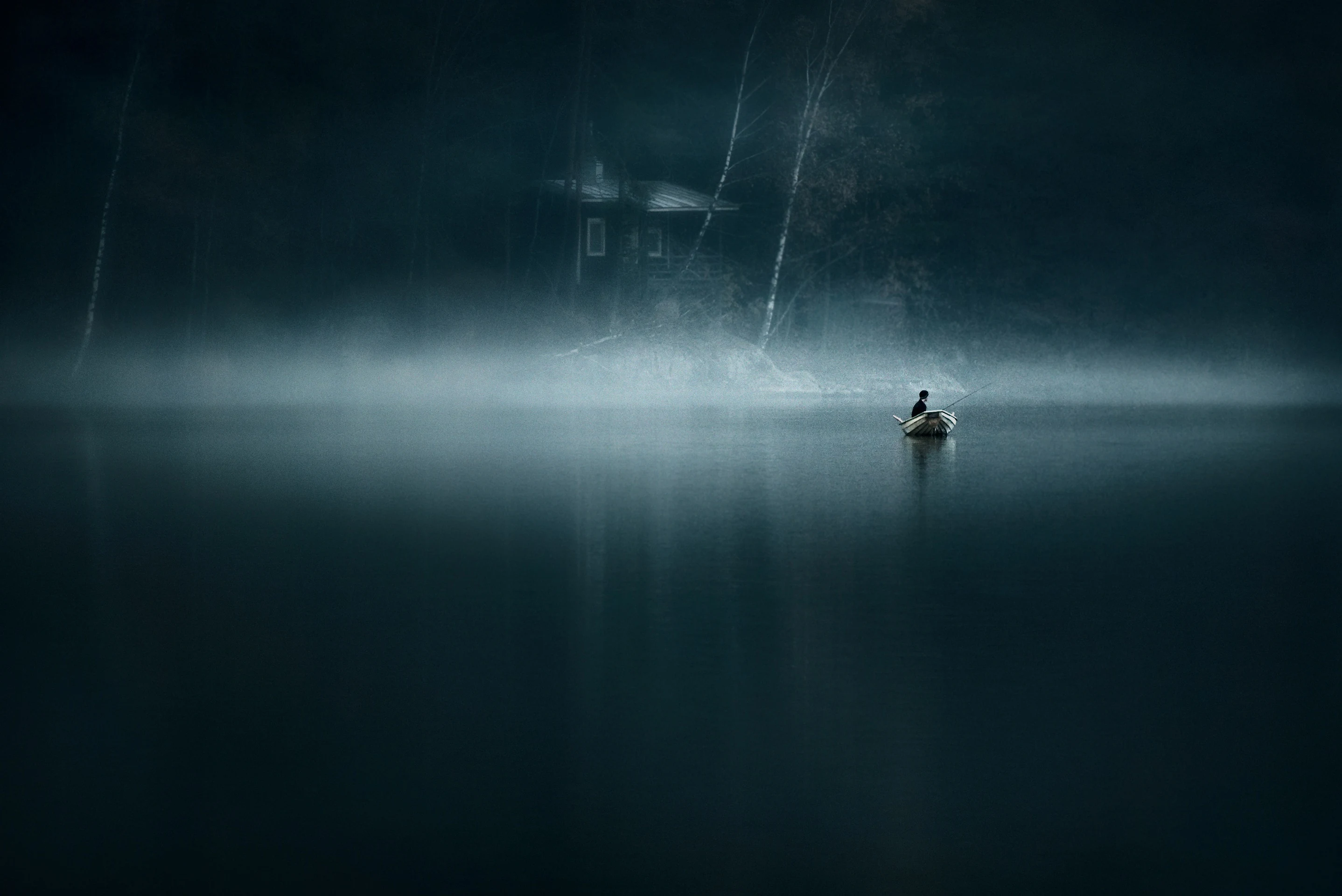 Lone fisherman rowing through misty blue hour water with a small cabin in the background